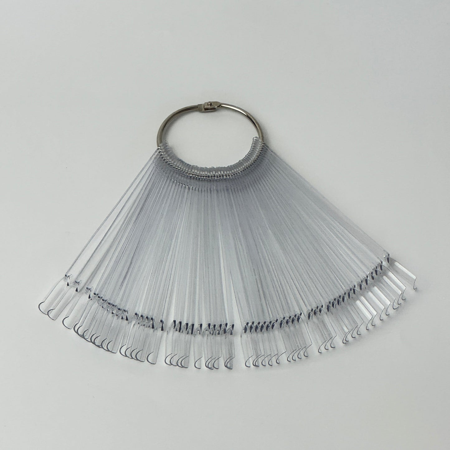 Clear acrylic nail swatch sticks showing various dipping powder and polish colours arranged in a fan displa