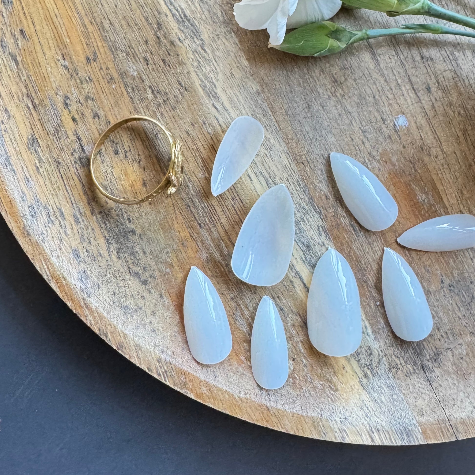 Close-up of sculpted mountain-shaped nail tips showing strong apex structure displayed in a tray